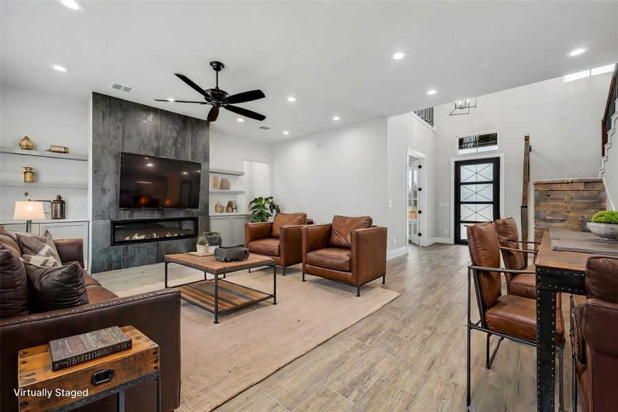 Living area featuring light wood finished floors, recessed lighting, visible vents, a ceiling fan, and a tile fireplace