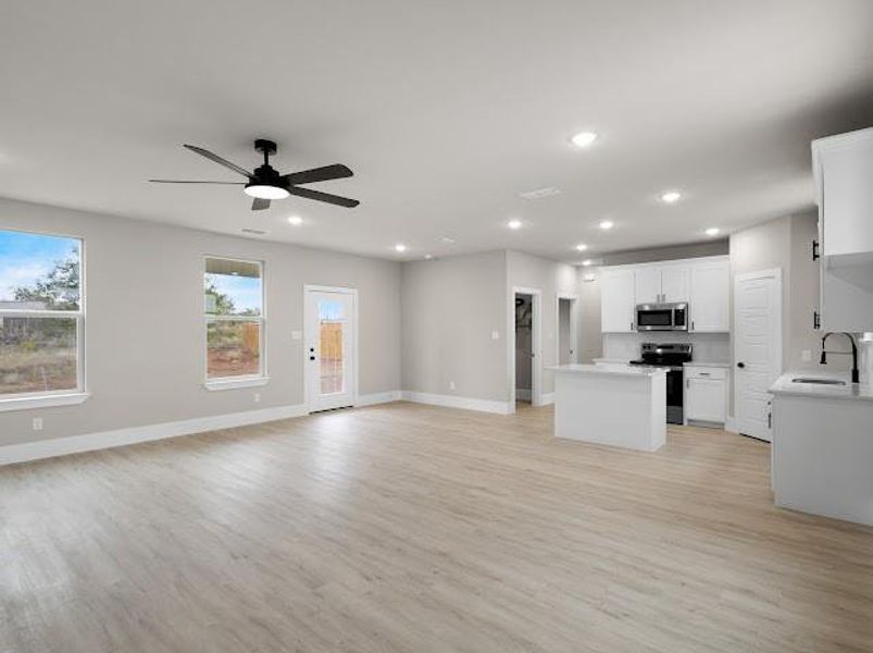 Unfurnished living room featuring light wood-style flooring, recessed lighting, and a ceiling fan
