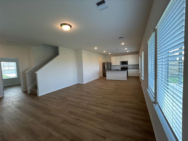 Unfurnished living room featuring stairs, dark wood-style floors, and recessed lighting
