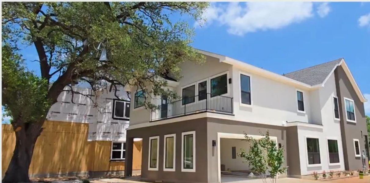 Back of house featuring a balcony, stucco siding, a patio area, and a garage
