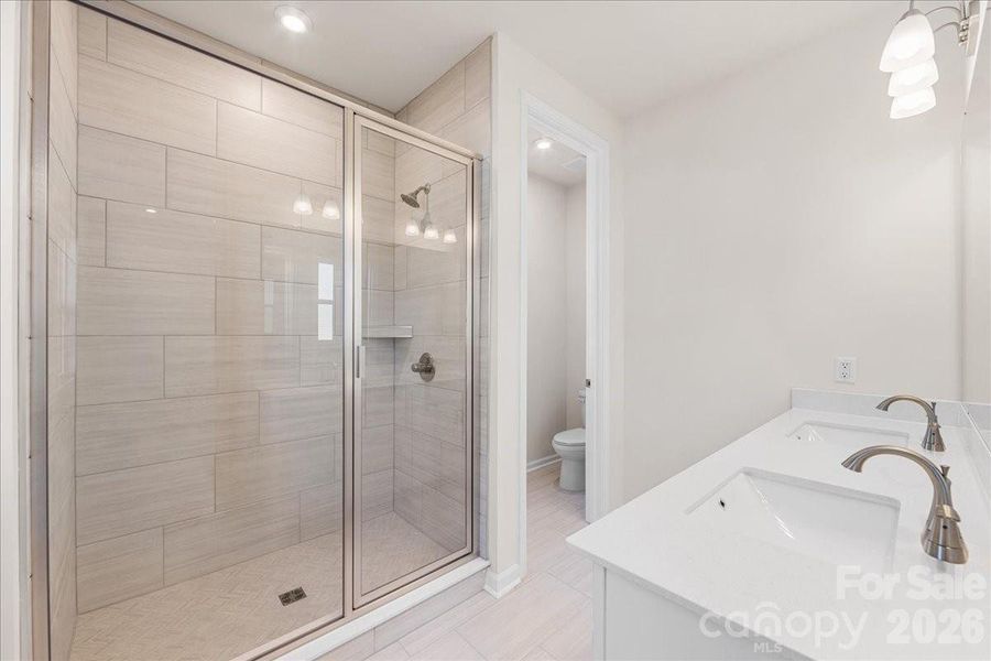 Primary Bathroom with tiled shower walls and floor pan