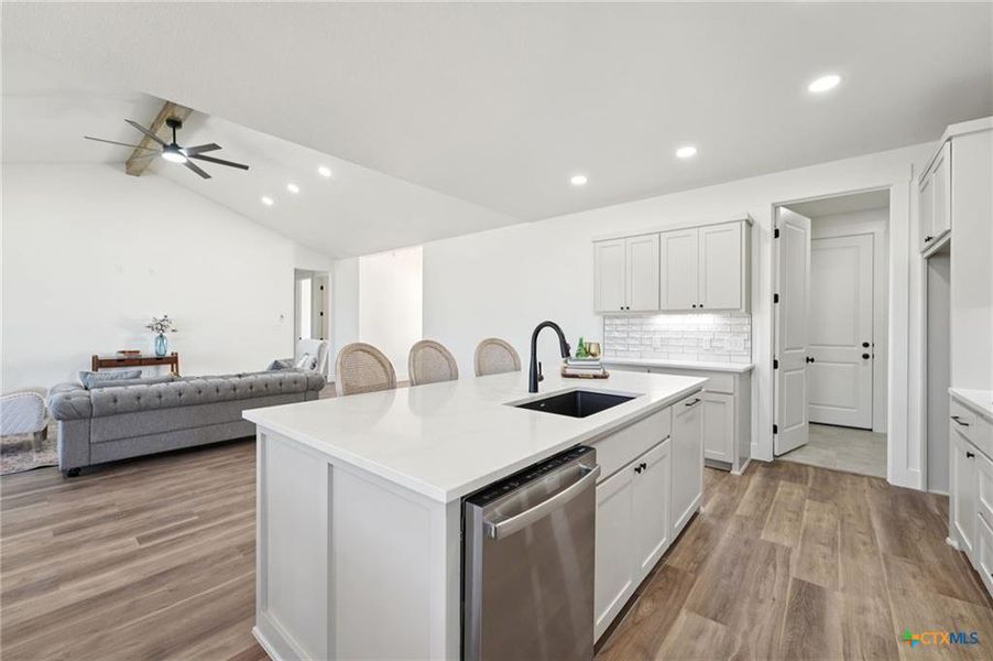 A seamless open-concept design unites the kitchen with a living area, featuring a spacious island and modern appliances. A seamless open-concept design unites the kitchen with a living area, featuring a spacious island and modern appliances.