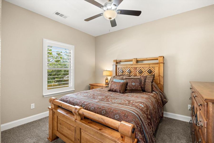 Carpeted bedroom with ceiling fan and baseboards Carpeted bedroom with ceiling fan and baseboards