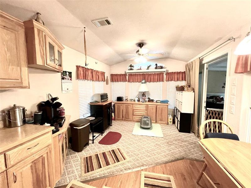 Kitchen featuring ceiling fan, light wood-type flooring, and vaulted ceiling Kitchen featuring ceiling fan, light wood-type flooring, and vaulted ceiling
