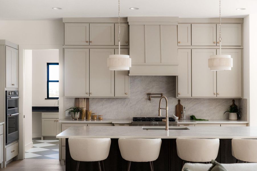 An inviting kitchen with a central island and contemporary lighting fixtures, ideal for entertaining.