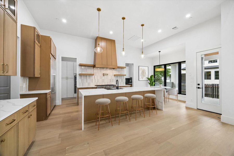 Pristine, immaculate and open design has filled the formal Kitchen with light and offers a great deal of storage and quartz counter space. The garage entry is to the left (SEE the plan) with mud room built-ins and beyond that is the laundry room.