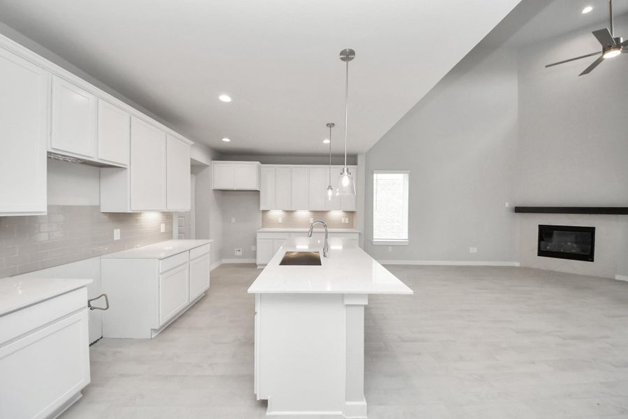 The kitchen is a culinary haven, featuring granite countertops, a tile backsplash, stainless steel appliances, 42” upper cabinets, and undercabinet lighting. Sample photo of completed home with similar floor plan. Actual colors and selections may vary. The kitchen is a culinary haven, featuring granite countertops, a tile backsplash, stainless steel appliances, 42” upper cabinets, and undercabinet lighting. Sample photo of completed home with similar floor plan. Actual colors and selections may vary.