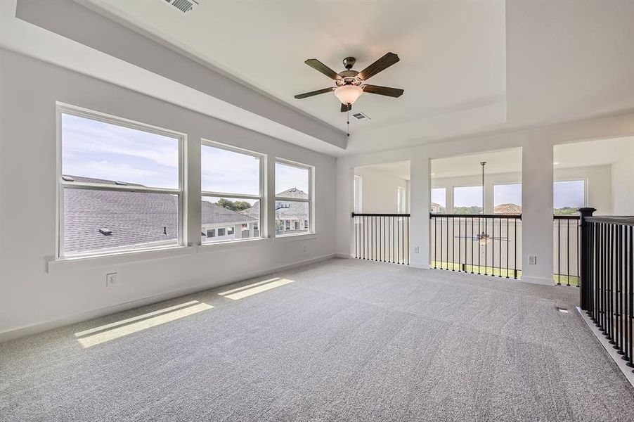 Spare room featuring a ceiling fan, carpet, a tray ceiling, and baseboards Spare room featuring a ceiling fan, carpet, a tray ceiling, and baseboards