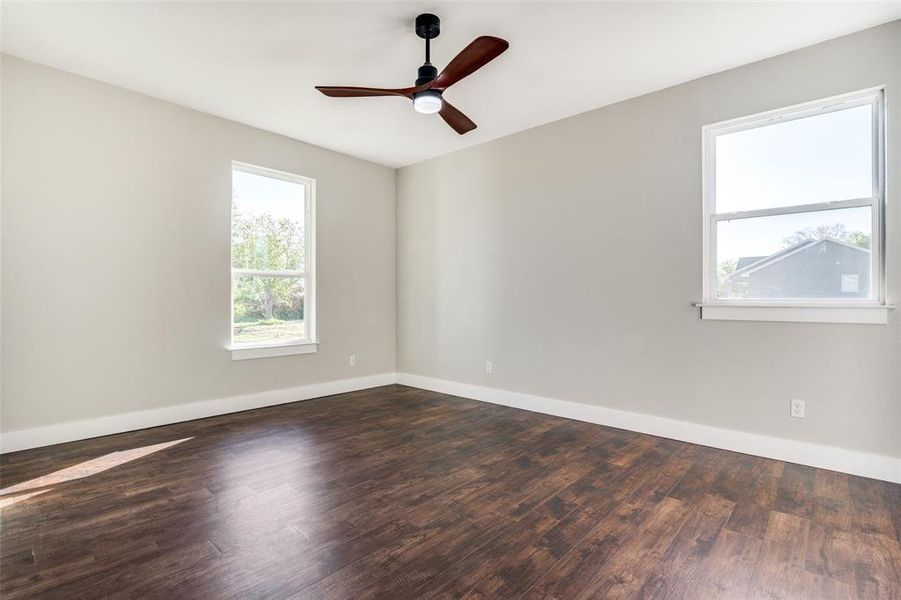 Spare room featuring ceiling fan and dark wood-type flooring