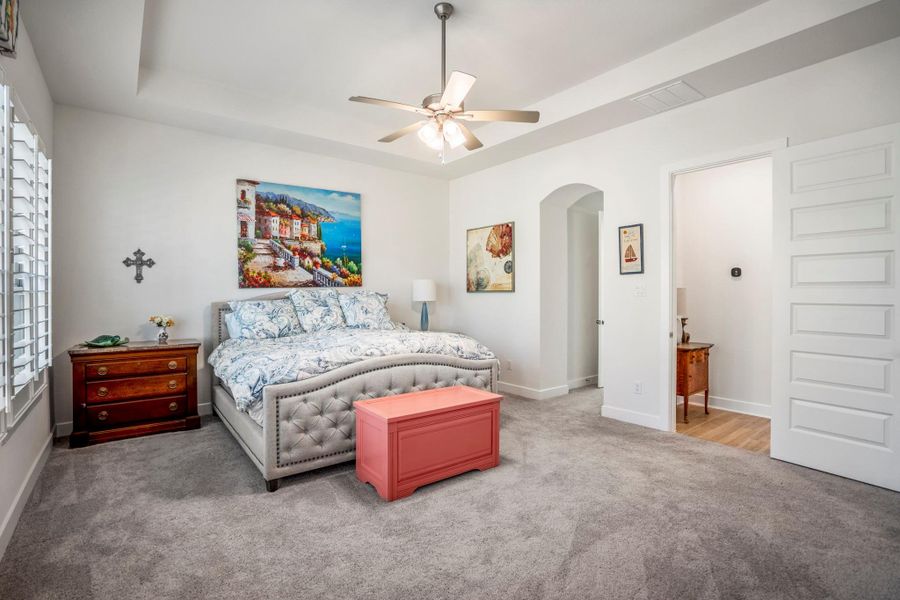 This first-floor primary retreat is light and bright with a view of the woods through a wall of windows.