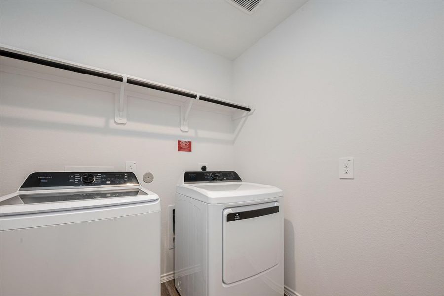The laundry room is thoughtfully outfitted with a built-in rack and hanging rod above the washer and dryer area. The laundry room is thoughtfully outfitted with a built-in rack and hanging rod above the washer and dryer area.