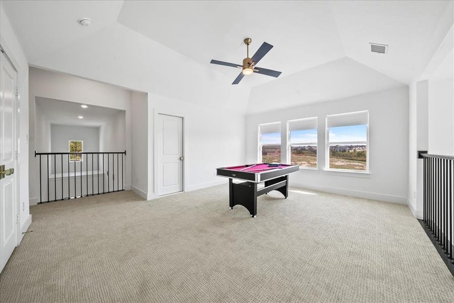 Recreation room with lofted ceiling, baseboards, visible vents, and carpet