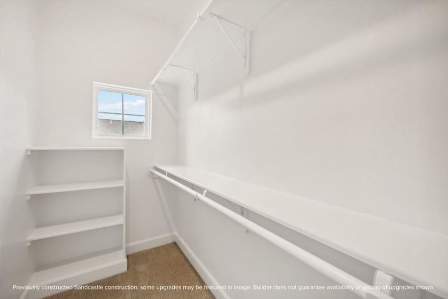 Stay Organized. This generously sized walk-in closet offers built-in shelving and ample hanging space.