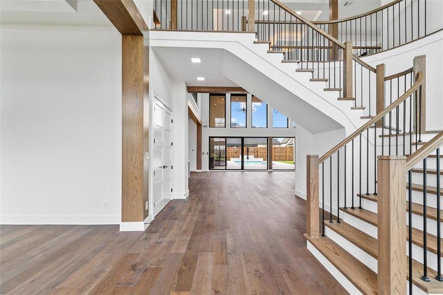 Entryway with a towering ceiling and dark wood-type flooring