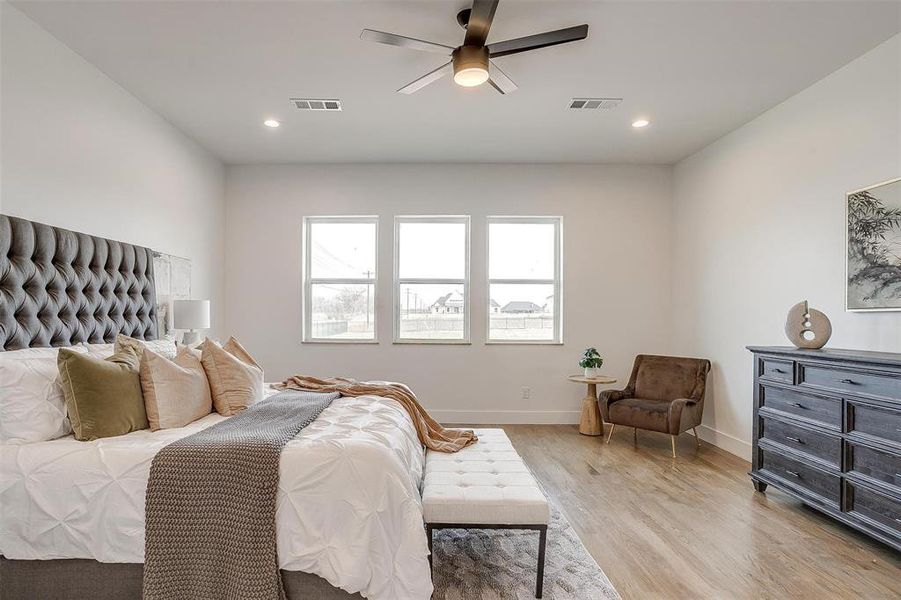 Bedroom with light wood-type flooring, visible vents, baseboards, and recessed lighting