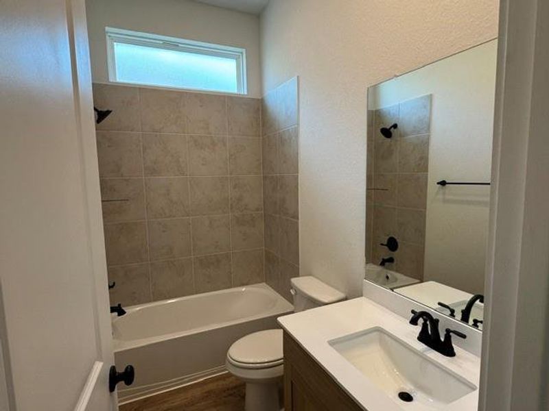A well-appointed bathroom features a bathtub and shower combination, with a vanity and mirror completing the space.