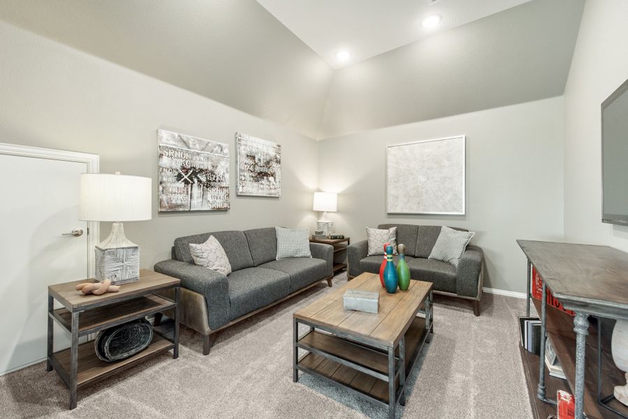 Living room with two gray sofas, wood coffee table, and vaulted ceiling with recessed lighting