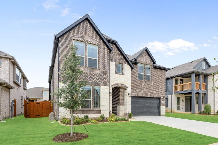 Two-story brick home with stone accents, two-car garage, and landscaped front yard Two-story brick home with stone accents, two-car garage, and landscaped front yard