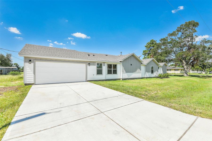 Wide driveway leads to a two-car garage positioned on the side of the home, maximizing curb appeal on this desirable corner lot.