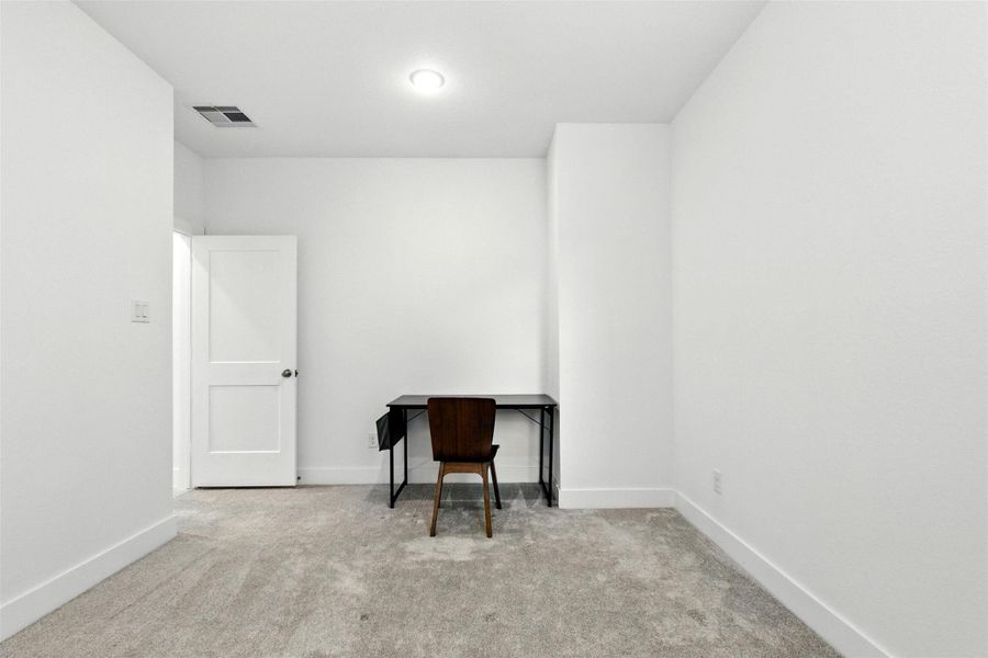 The secondary first floor bedroom features a largewindow and plush carpet. The secondary first floor bedroom features a largewindow and plush carpet.