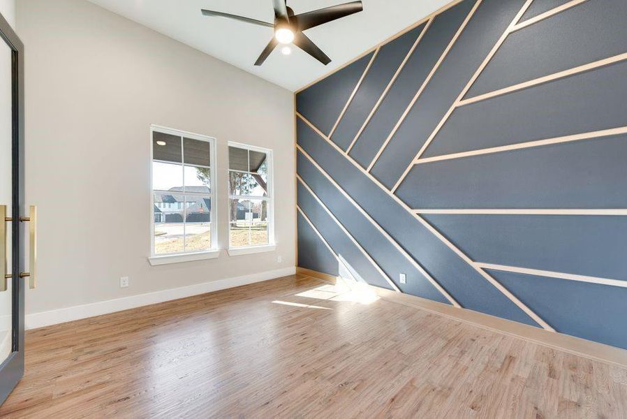 Empty room with ceiling fan and hardwood / wood-style flooring