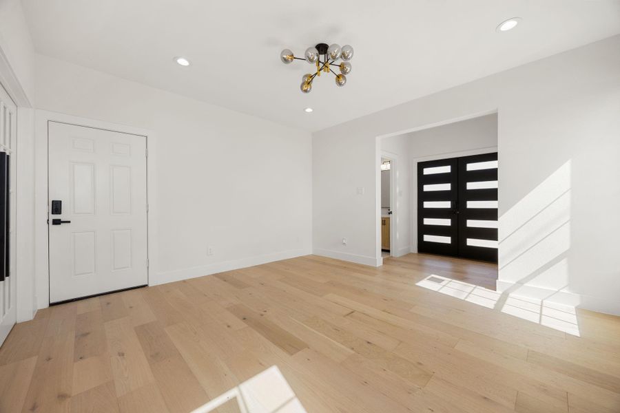 A central view of the spacious living area, showcasing the beautiful light fixture, modern doors, and open layout that creates a welcoming space for everyday living   and entertaining.