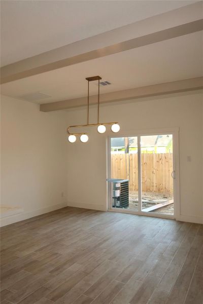 The dining room boasts luxury vinyl flooring, a stylish gold light fixture, and sliding doors that open to the backyard. The dining room boasts luxury vinyl flooring, a stylish gold light fixture, and sliding doors that open to the backyard.