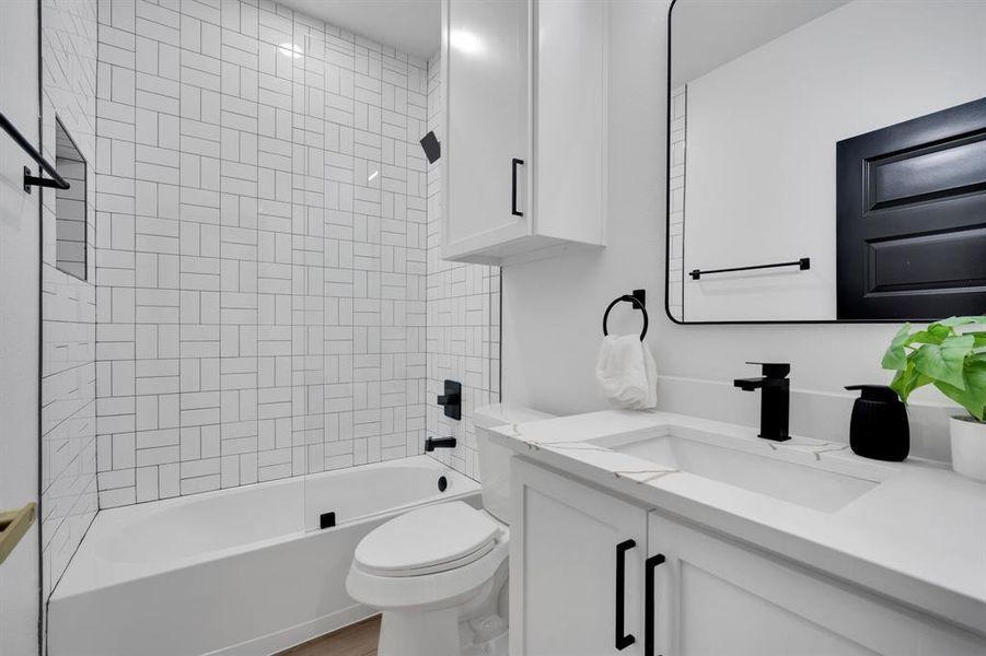 Second full bathroom with tub and tile.  Quartz counters accent this bathroom.