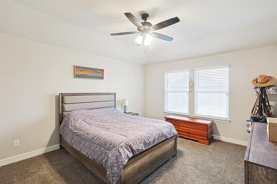 Carpeted bedroom featuring baseboards and a ceiling fan