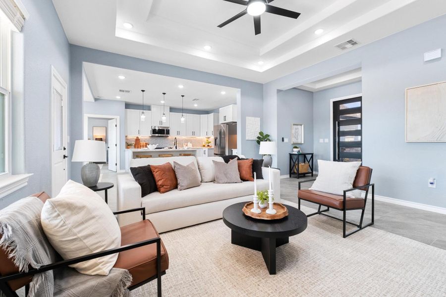 Living room featuring ceiling fan, recessed lighting, and a raised ceiling Living room featuring ceiling fan, recessed lighting, and a raised ceiling