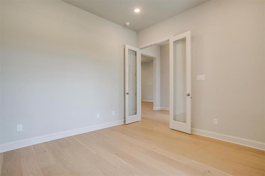 Empty room featuring french doors and light hardwood / wood-style floors