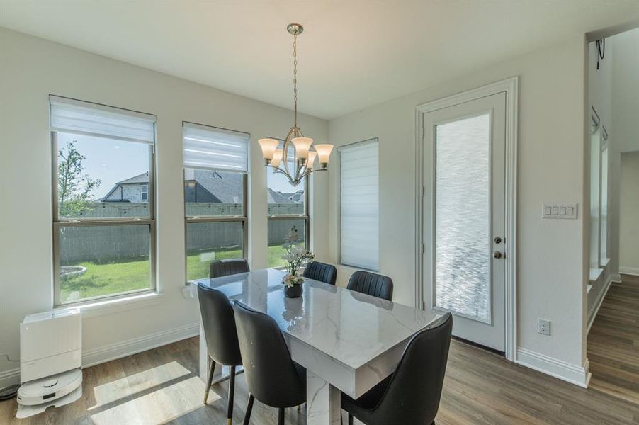 Dining area with wood-finish flooring and a contemporary chandelier
