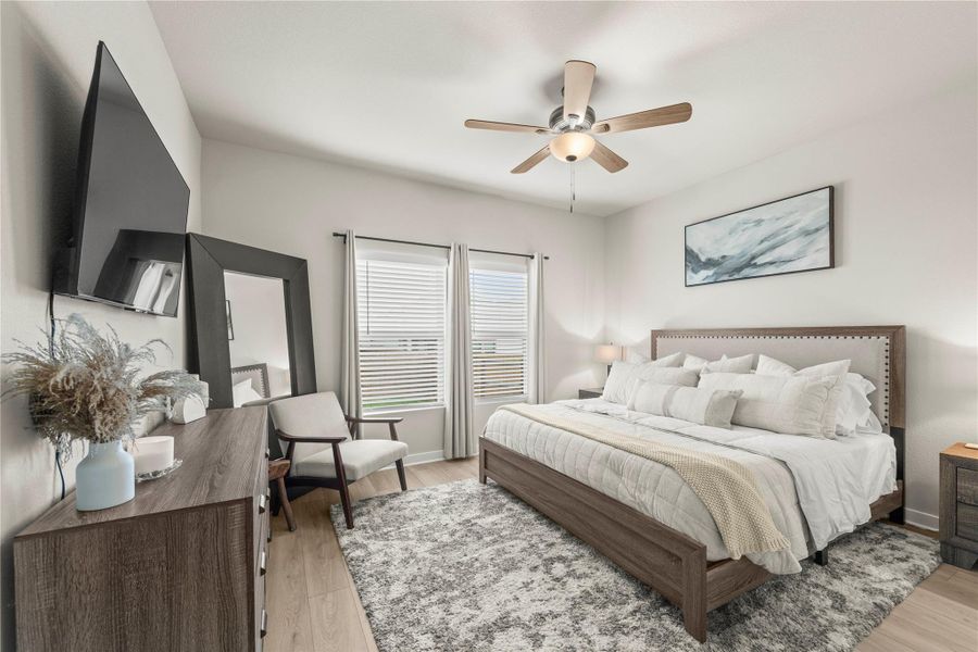 Well-lit sleeping quarters with a ceiling fan, a generous area rug, and large windows. Well-lit sleeping quarters with a ceiling fan, a generous area rug, and large windows.