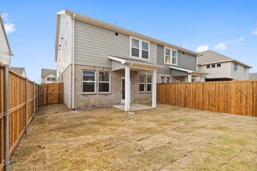 Rear view of property featuring a patio and a lawn