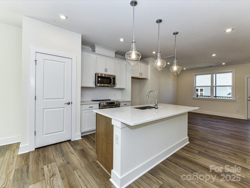 Designer Pendant Lighting and Cabinet Color Change at Island Adds Design Interest.