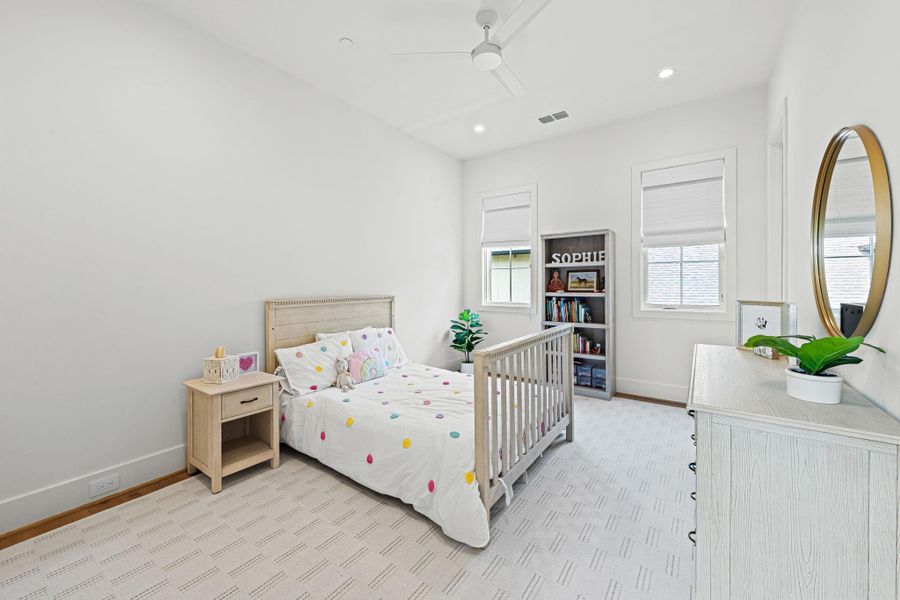 Located upstairs, this secondary bedroom #2 offers a comfortable, well-designed space w/ wide-plank white oak flooring & a ceiling fan for added comfort. Windows w/ custom woven Roman shades overlook the side yard, bringing in natural light. A walk-in closet w/ built-in drawers, shelving & hanging space provides excellent storage. Located upstairs, this secondary bedroom #2 offers a comfortable, well-designed space w/ wide-plank white oak flooring & a ceiling fan for added comfort. Windows w/ custom woven Roman shades overlook the side yard, bringing in natural light. A walk-in closet w/ built-in drawers, shelving & hanging space provides excellent storage.