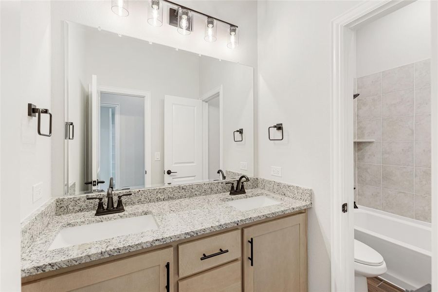 Bathroom with double sink vanity, granite countertop, and tiled shower-tub combo Bathroom with double sink vanity, granite countertop, and tiled shower-tub combo