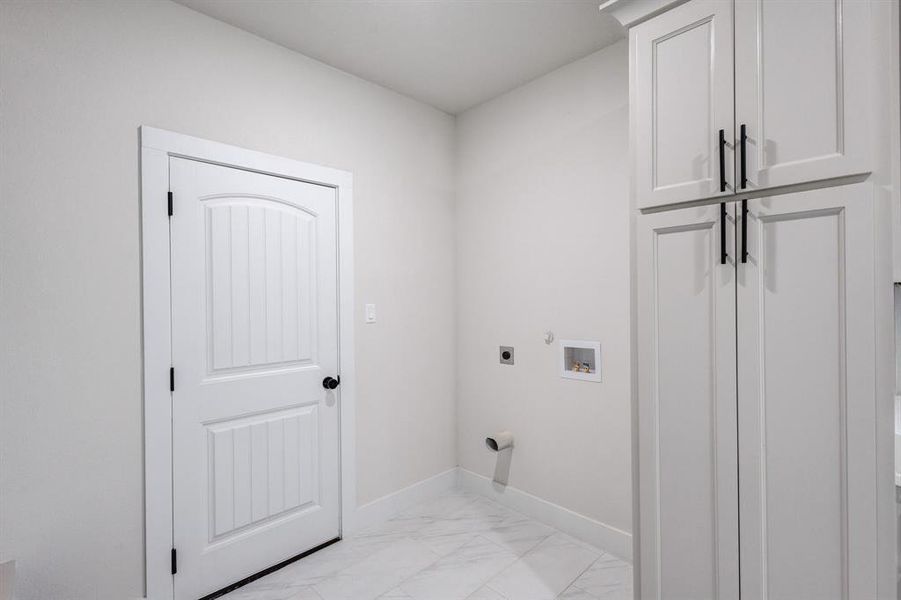 Clothes washing area featuring washer hookup, cabinets, and hookup for an electric dryer