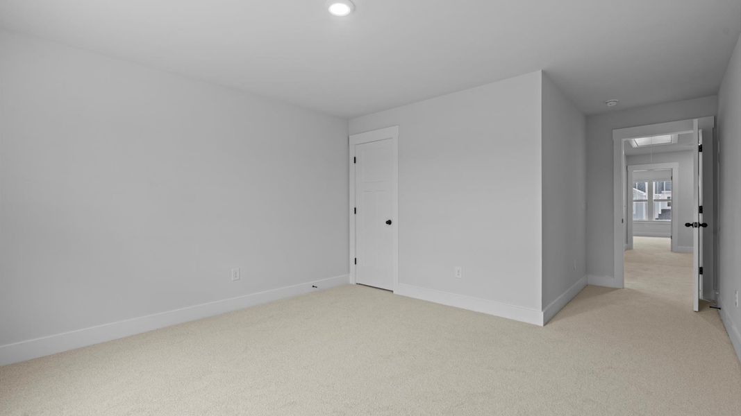 Notable secondary bedroom offering cozy carpeted flooring and a stylish walk-in closet