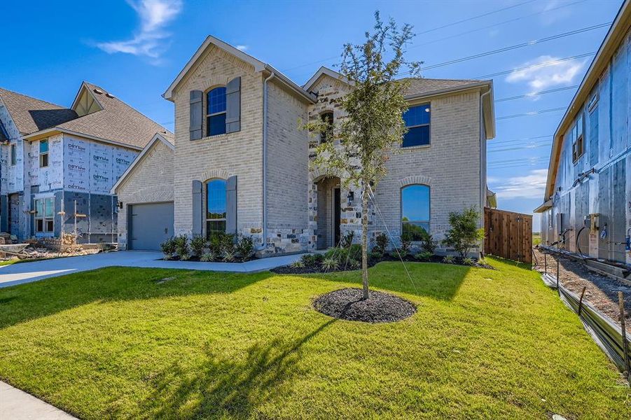 French country home with brick siding and driveway