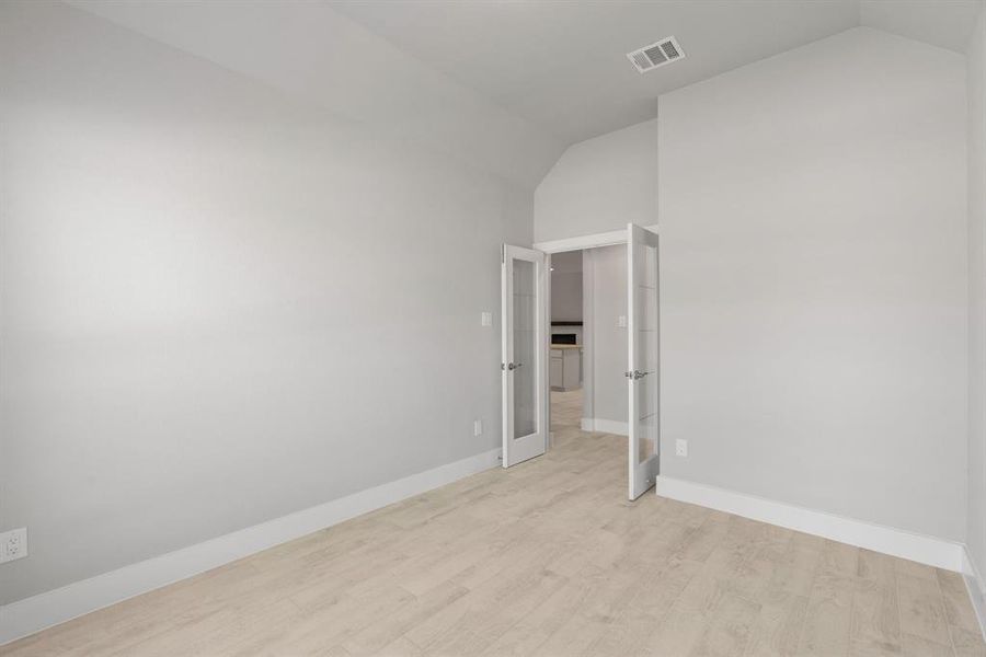 At the forefront, a refined home office beckons productivity and focus. Luxurious details like elegant tile, custom paint, expansive windows with privacy blinds, and French doors create an inspiring workspace. Sample photo of completed home with similar floor plan. Actual colors and selections may vary.