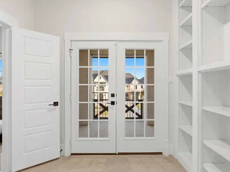 Double French doors with divided lites open to an exterior balcony Double French doors with divided lites open to an exterior balcony