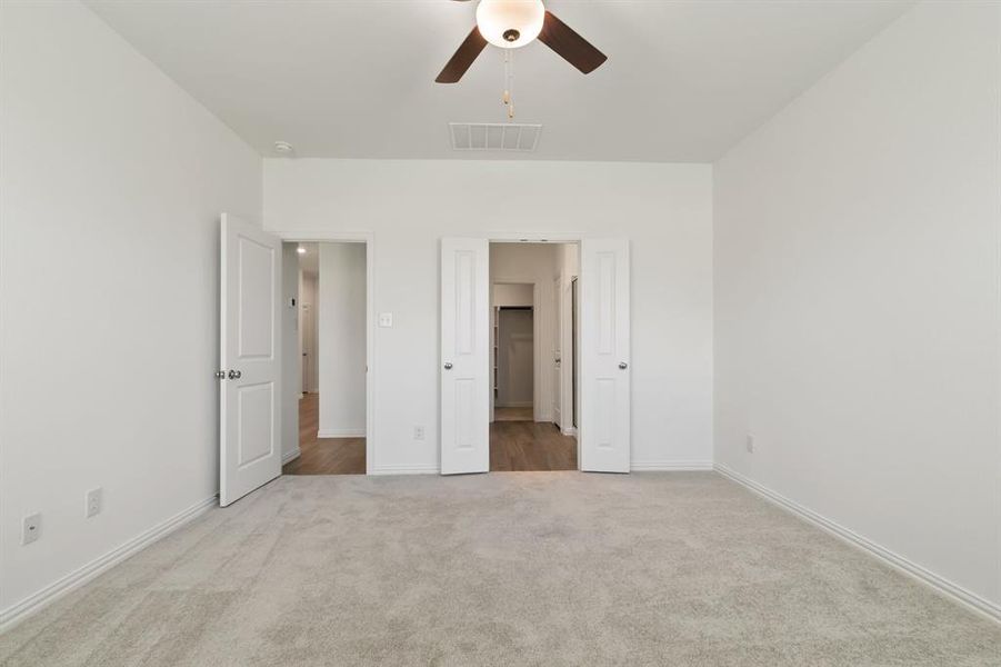 Unfurnished bedroom featuring ceiling fan and carpet floors