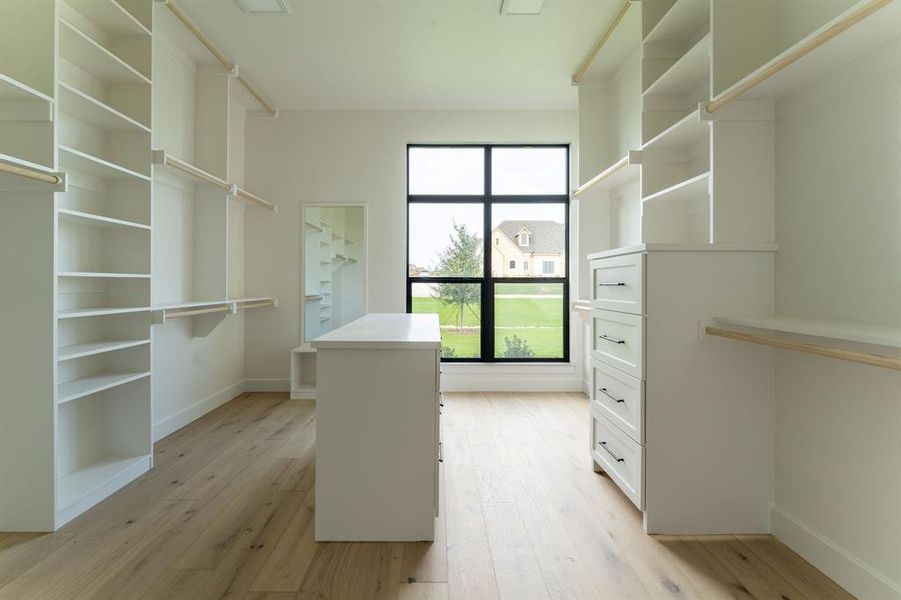 Spacious closet with light wood-style flooring Spacious closet with light wood-style flooring