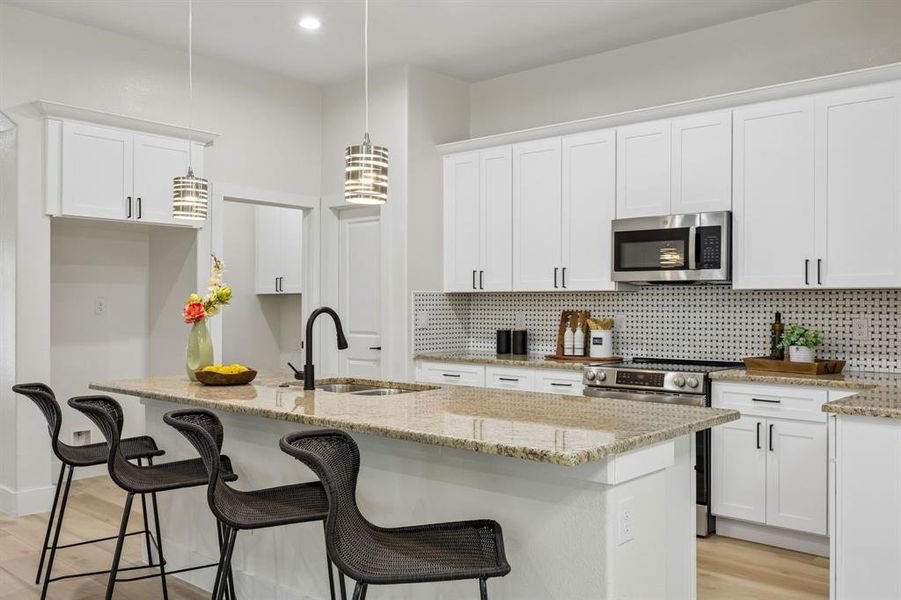 Kitchen featuring white shaker cabinetry here you can the pantry door and into the laundry room
