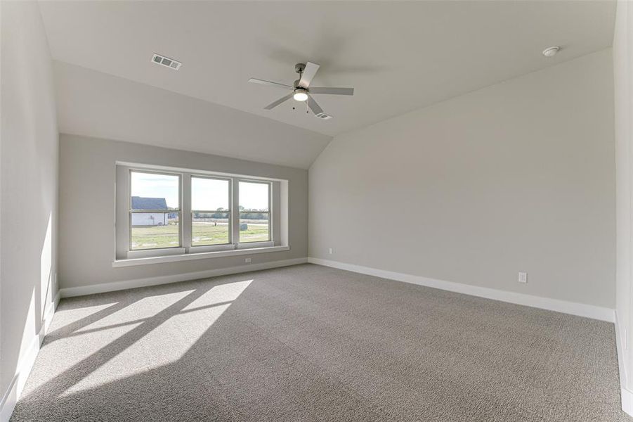 Unfurnished room featuring light carpet, vaulted ceiling, and ceiling fan