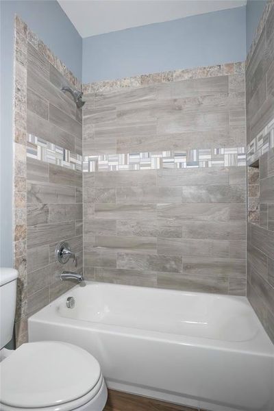 Bathroom with toilet and tiled shower / bath