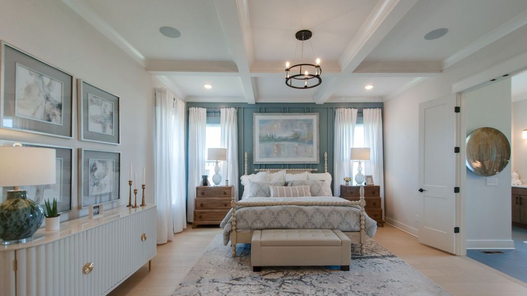 Large primary suite with trim-built coffered ceiling and entry to bathroom Large primary suite with trim-built coffered ceiling and entry to bathroom