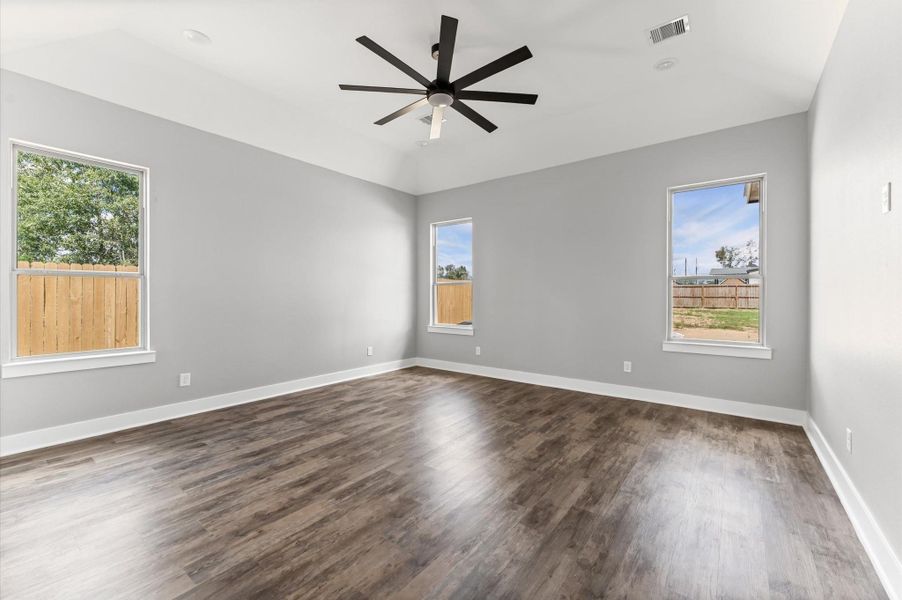 Spacious primary bedroom with high ceilings and a serene ambiance. Spacious primary bedroom with high ceilings and a serene ambiance.