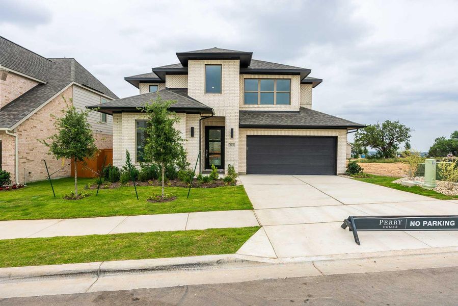 Prairie-style home with an attached garage, a front lawn, and brick siding Prairie-style home with an attached garage, a front lawn, and brick siding